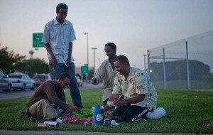 ALYSSA SCHUKAR/THE WORLD-HERALD From left, Abdikafi Kheyre, Ali Abdi, Fathi Nor and Abdikadir Omar break their daylong fast during Ramadan while waiting for fares Aug. 23 outside Eppley Airfield. Omar brought food from home that his wife had prepared for him and for other drivers who have no family here.